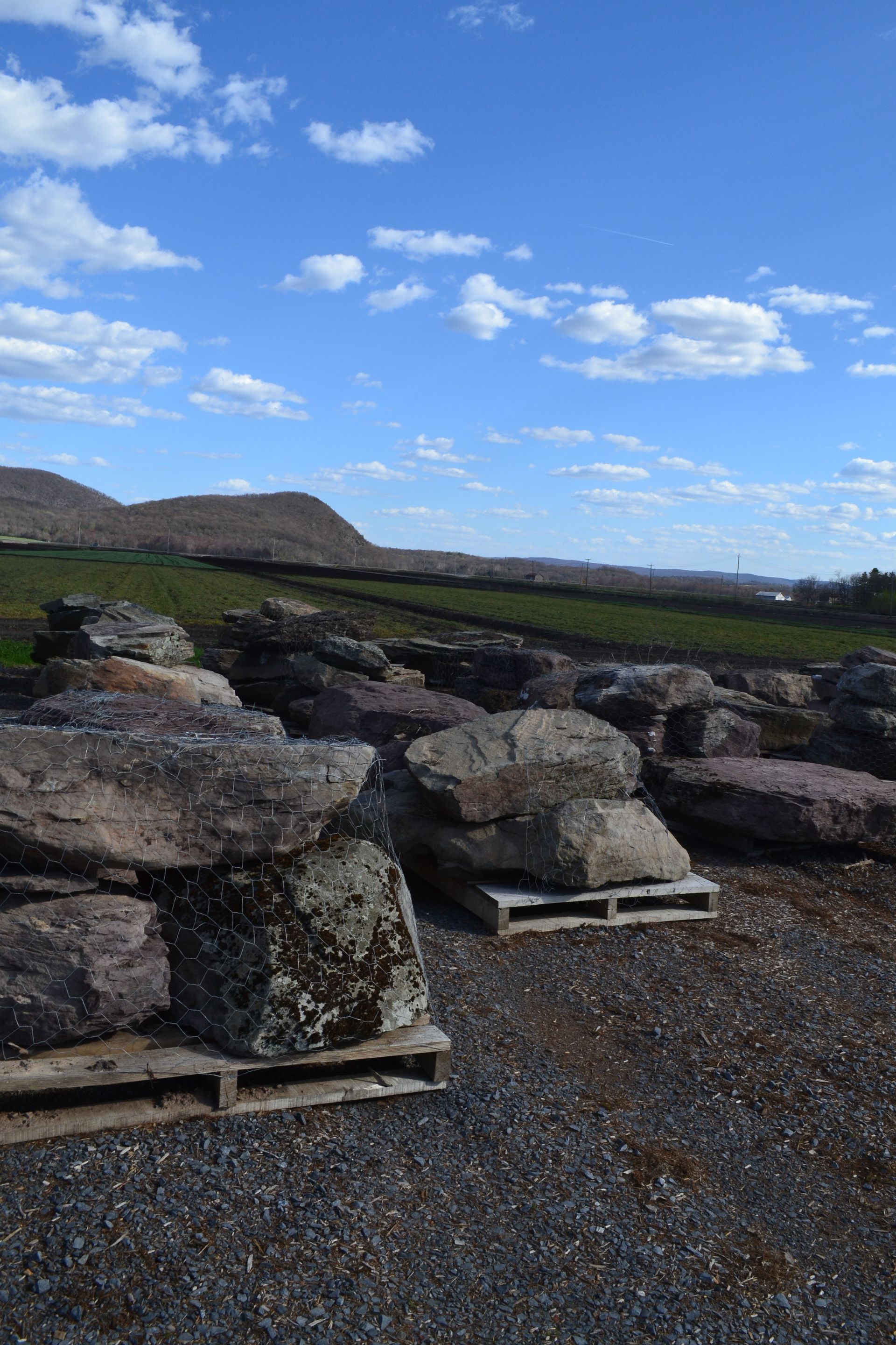a pile of rocks sitting on top of wooden pallets in a field