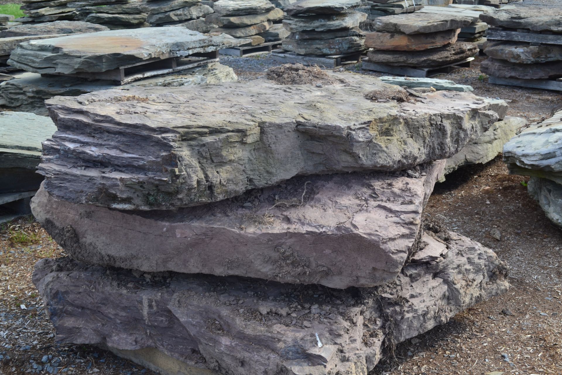a pile of rocks are stacked on top of each other on the ground