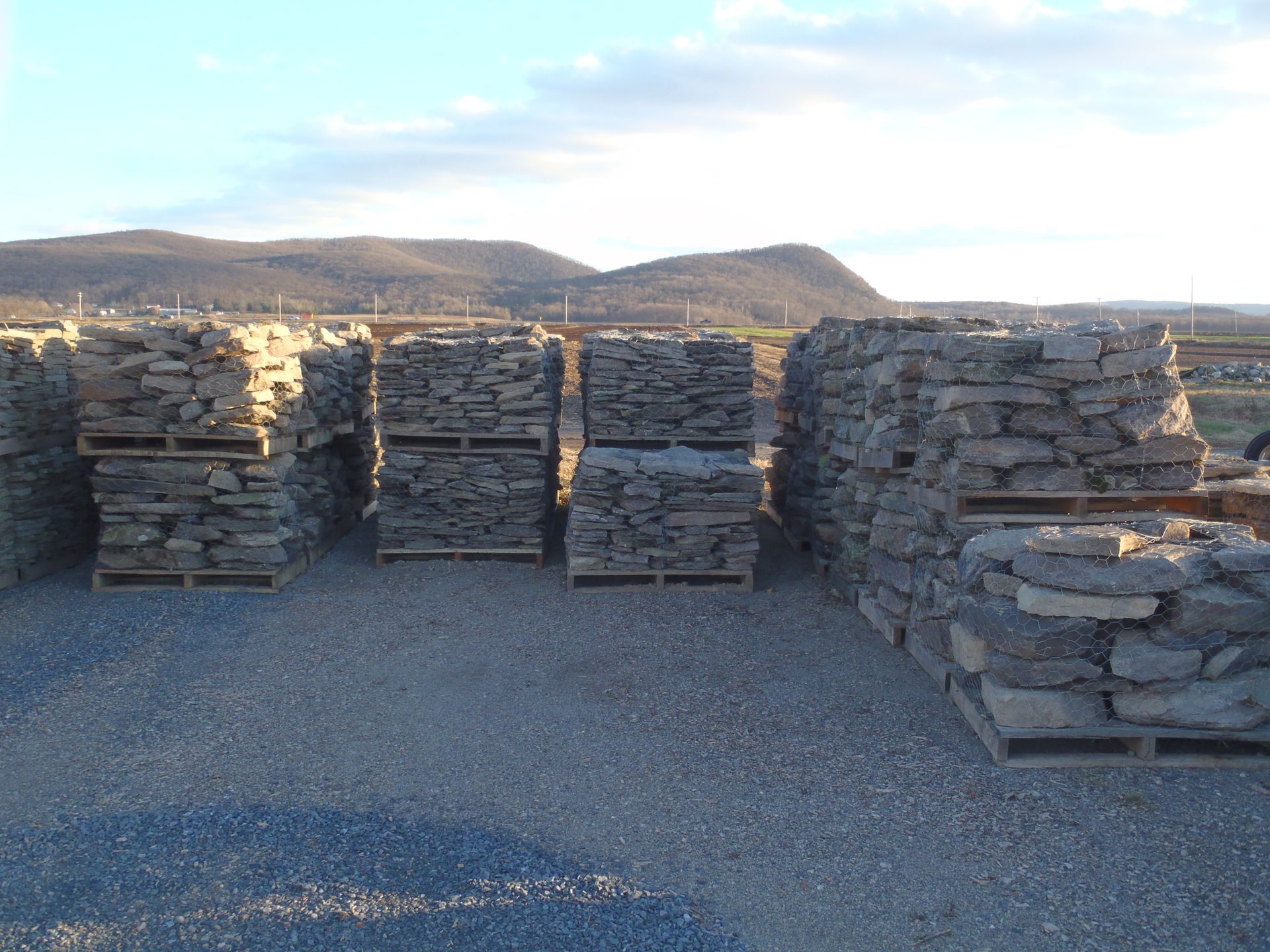 pallets of rocks are stacked on top of each other in a gravel area