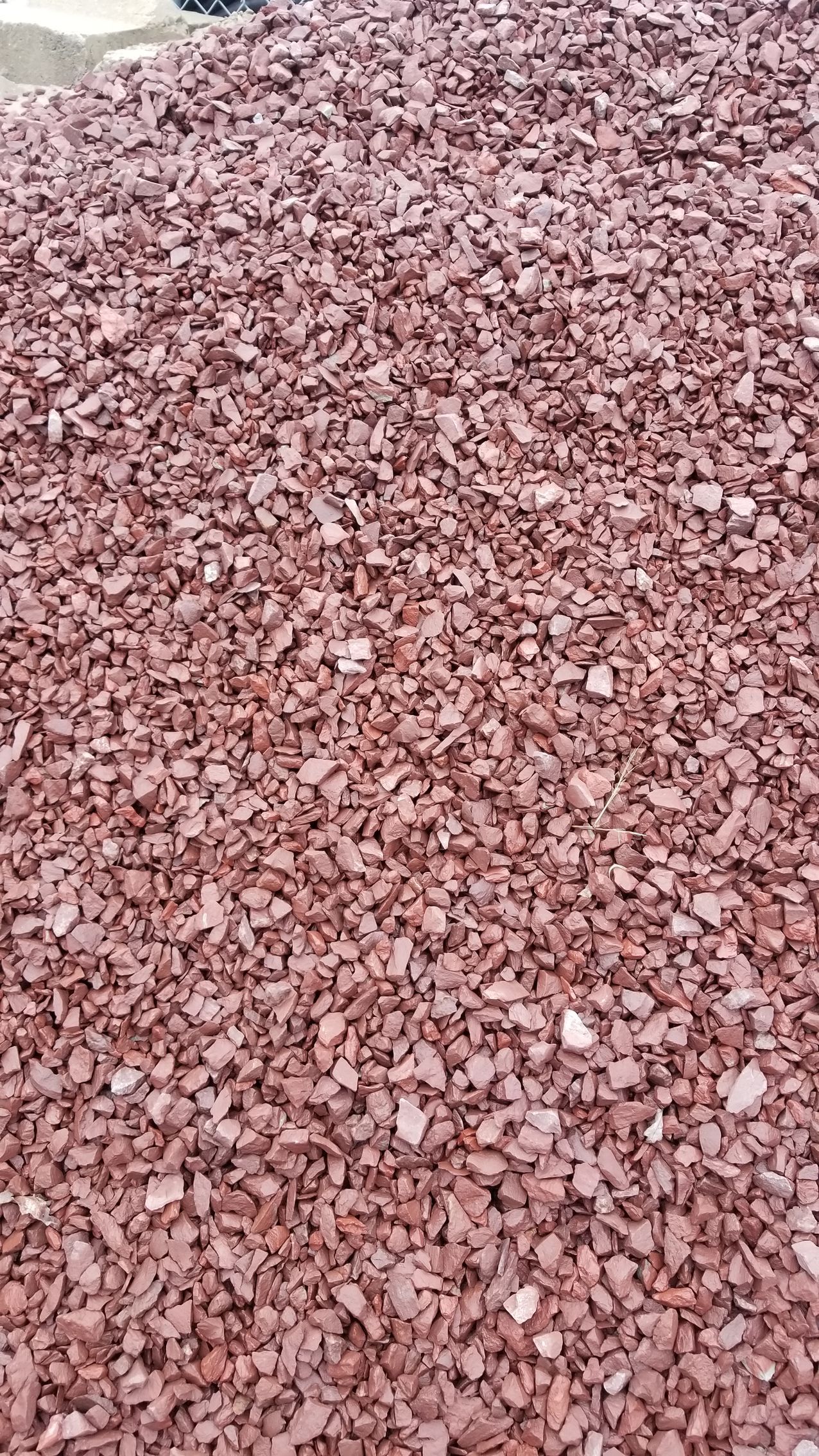 a pile of red gravel is sitting on the ground