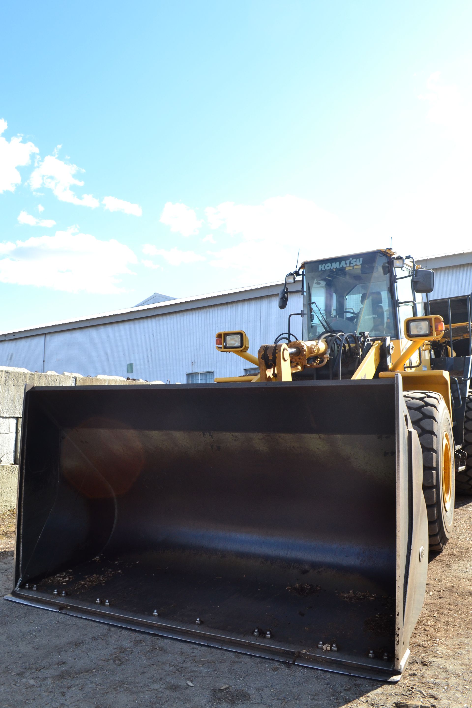 a bulldozer with a large bucket is parked in front of a building