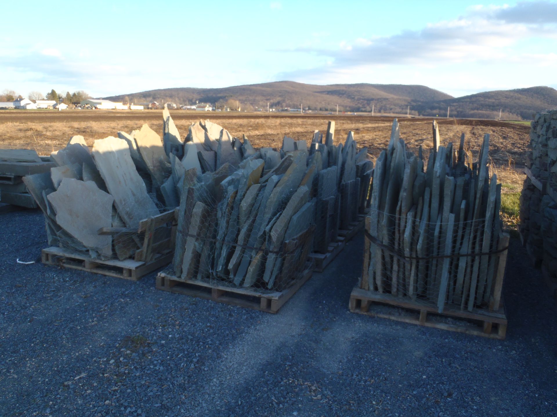 a pile of rocks on wooden pallets in a field