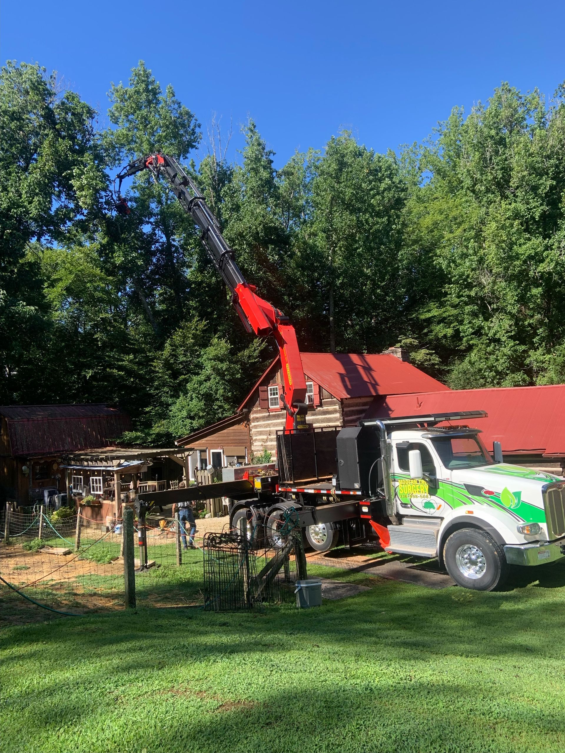 A truck with a crane attached to it is parked in front of a house.