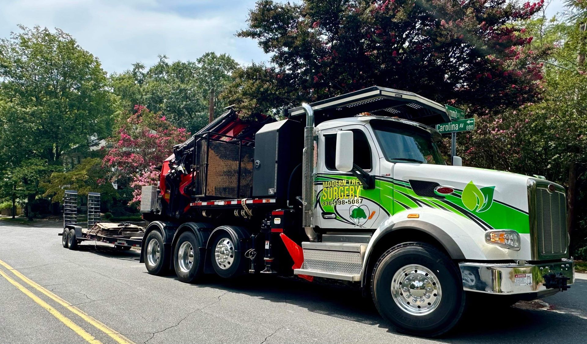 A white and green semi truck is parked on the side of the road.