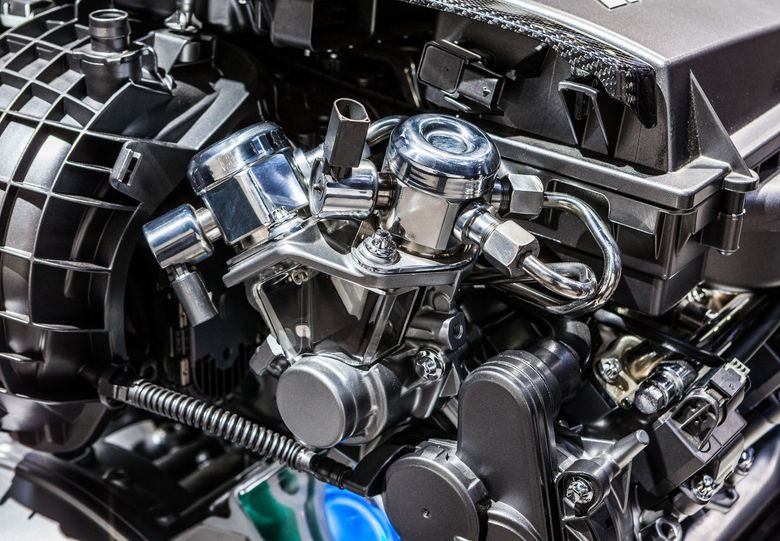 Close-up of a shiny, chrome-plated car engine with various tubes and parts.