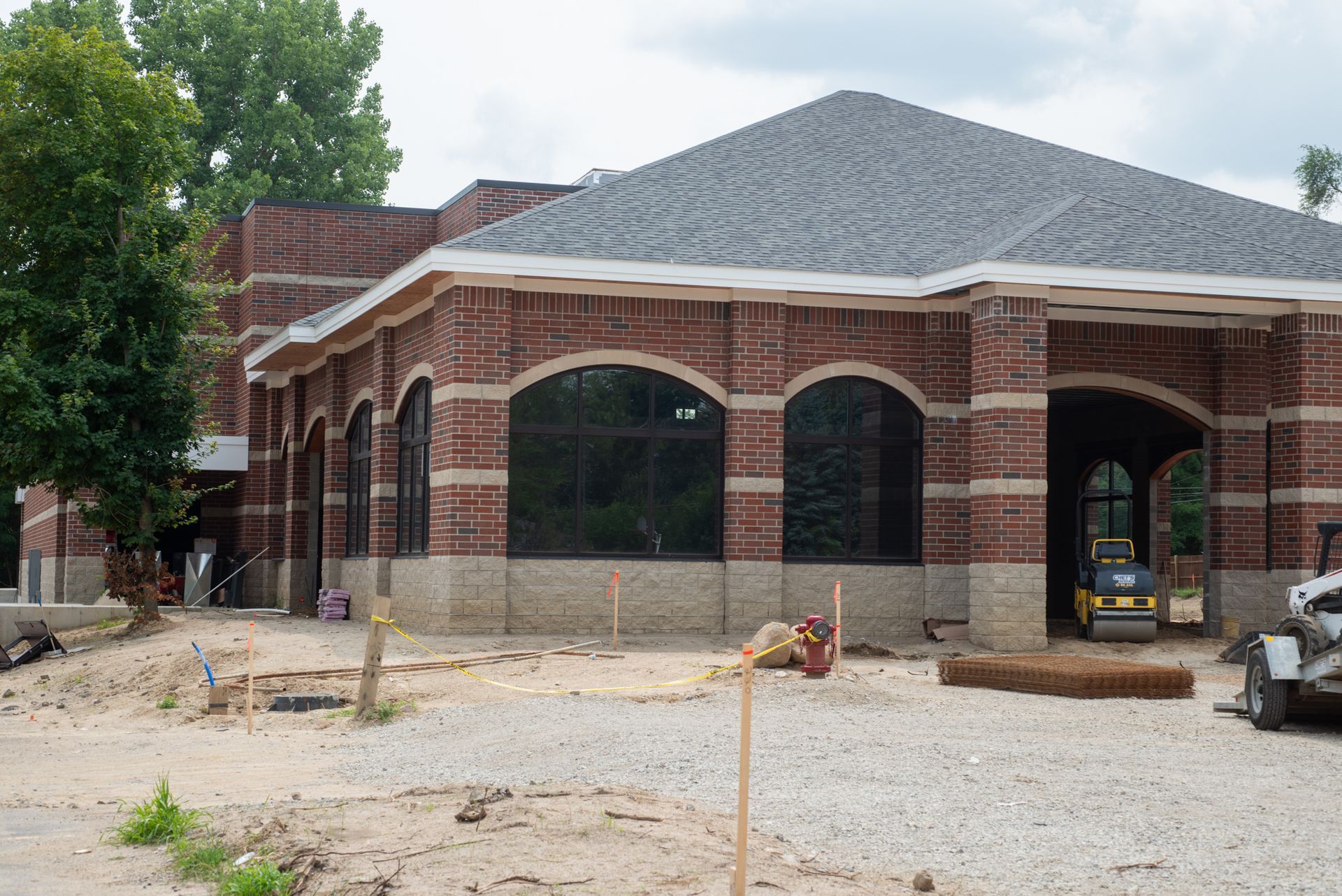 A large brick building with a gray roof is being built.