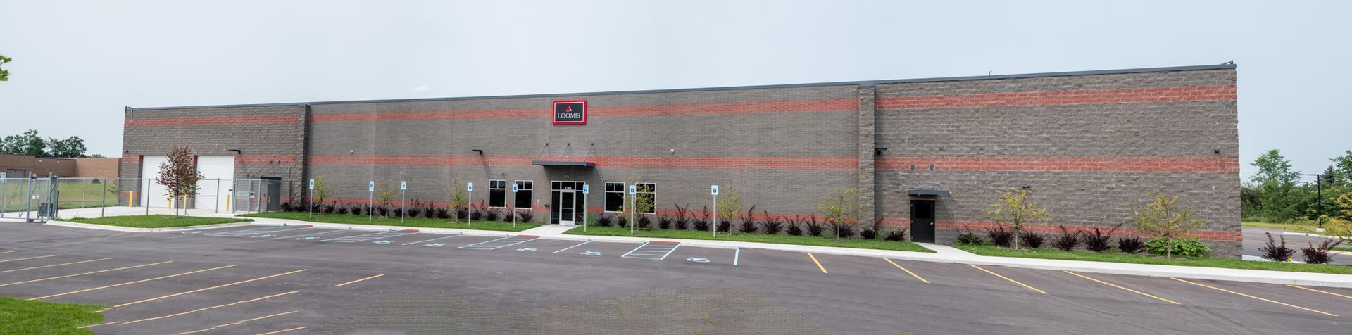A large brick building with a parking lot in front of it.