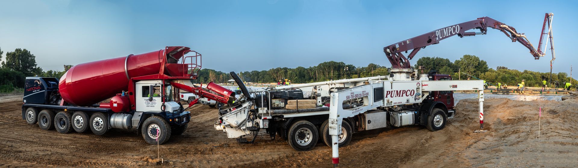 A mixer truck and a pump truck are parked next to each other on a dirt road.