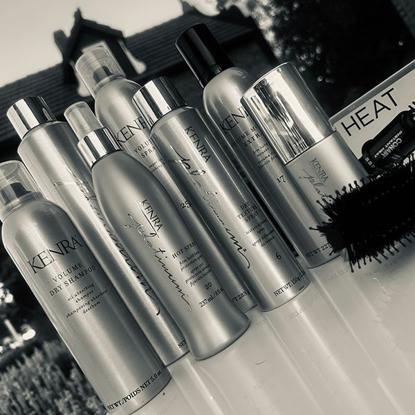 Kenra hair products arranged with a brush; outdoors, black and white.