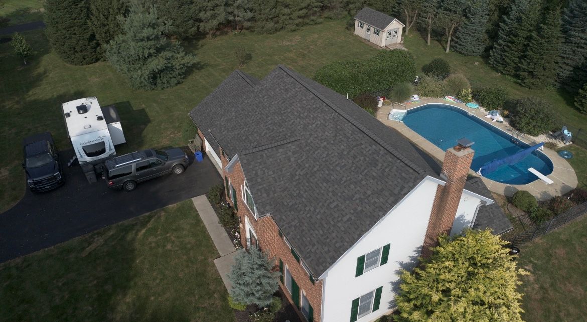 An aerial view of a house with a pool in the backyard.