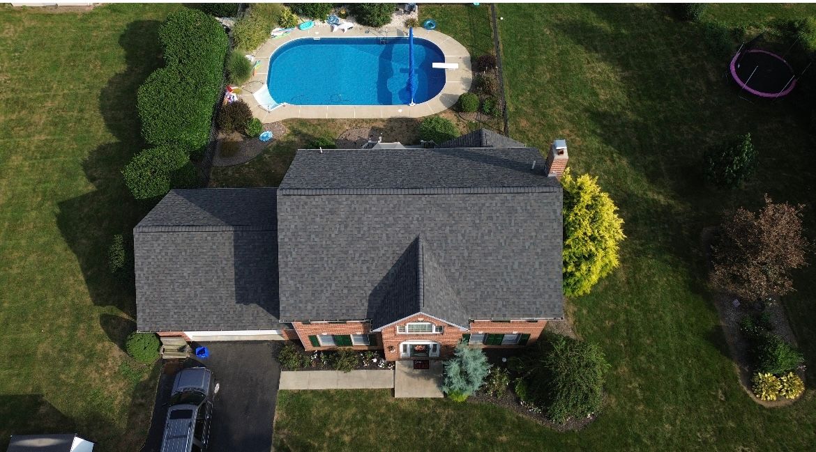 An aerial view of a house with a pool in the backyard.