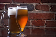 Glasses of beer in a brick background