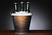 Three bottles of beers on a bucket of ice
