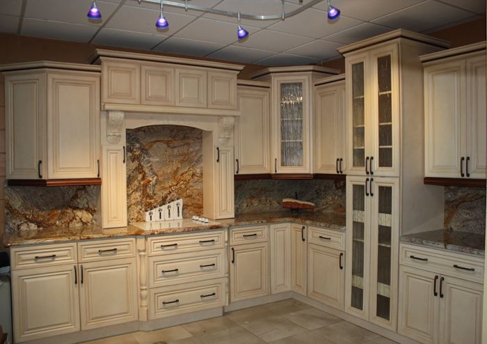 A kitchen with white cabinets and granite counter tops.