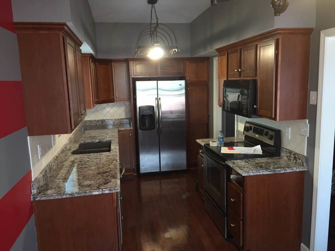 A kitchen with stainless steel appliances and granite counter tops.