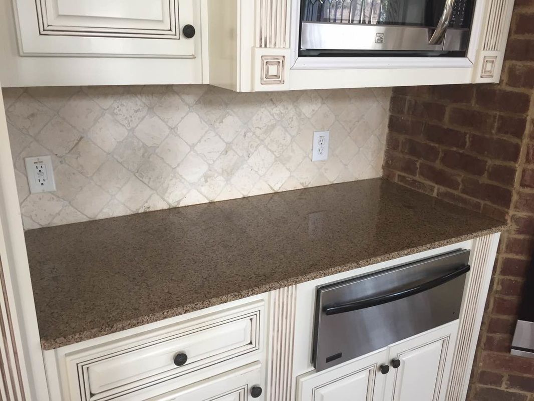 A kitchen with white cabinets and stainless steel appliances.