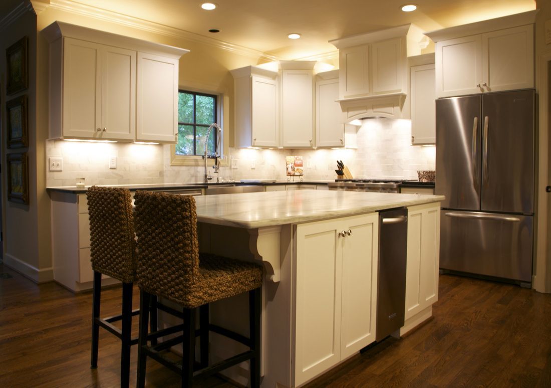 A kitchen with white cabinets and stainless steel appliances