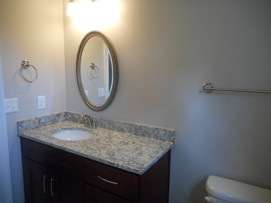 A bathroom with a sink , mirror and toilet.