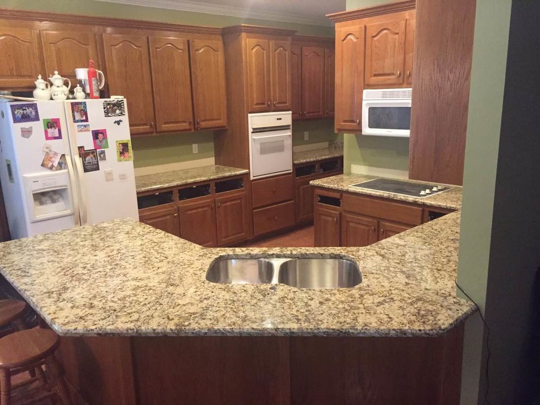 A kitchen with granite counter tops , stainless steel appliances , and wooden cabinets.