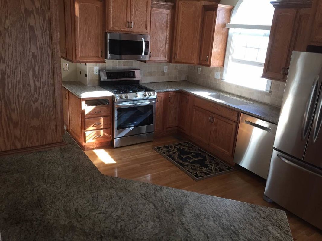 A kitchen with stainless steel appliances and wooden cabinets