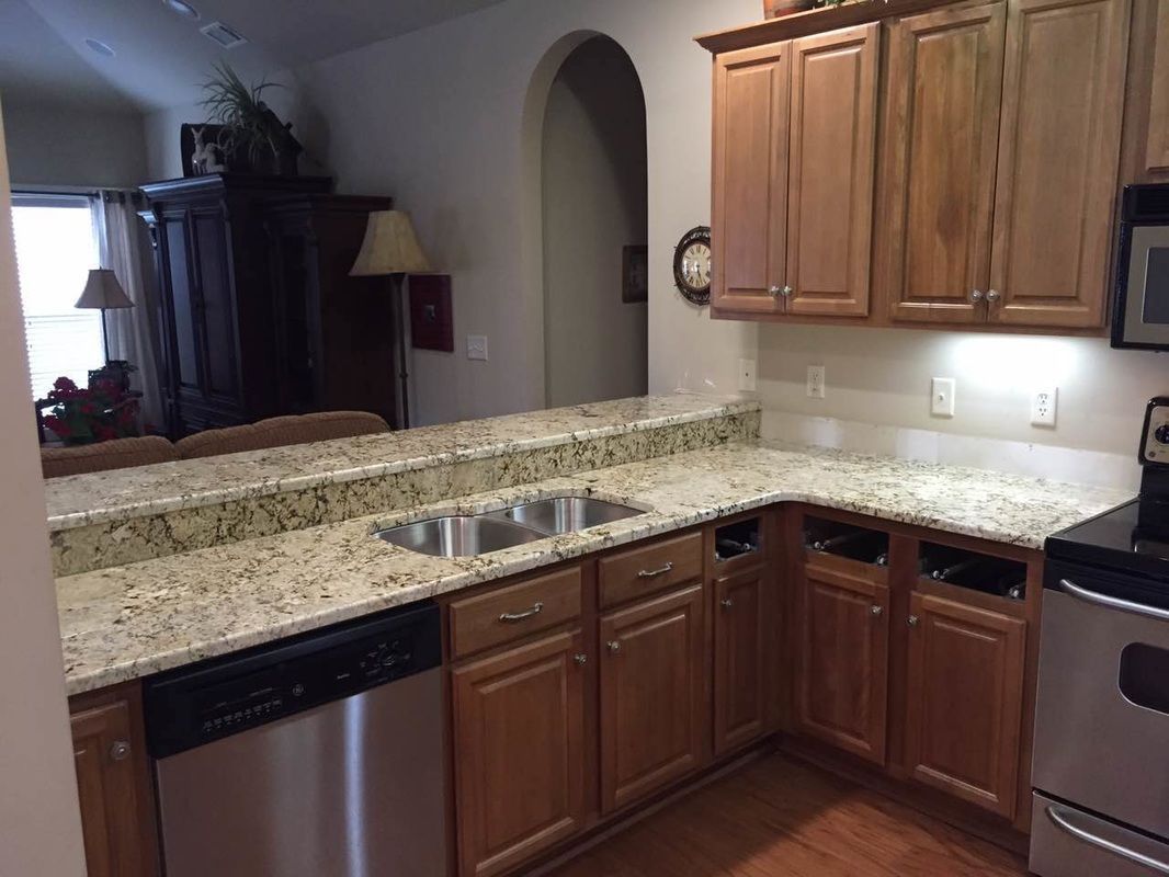 A kitchen with stainless steel appliances and granite counter tops.
