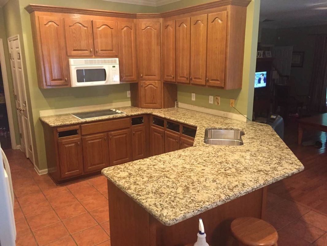 A kitchen with wooden cabinets and granite counter tops.