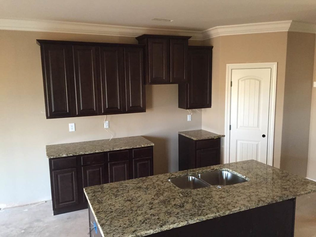 A kitchen with a sink , cabinets and granite counter tops.