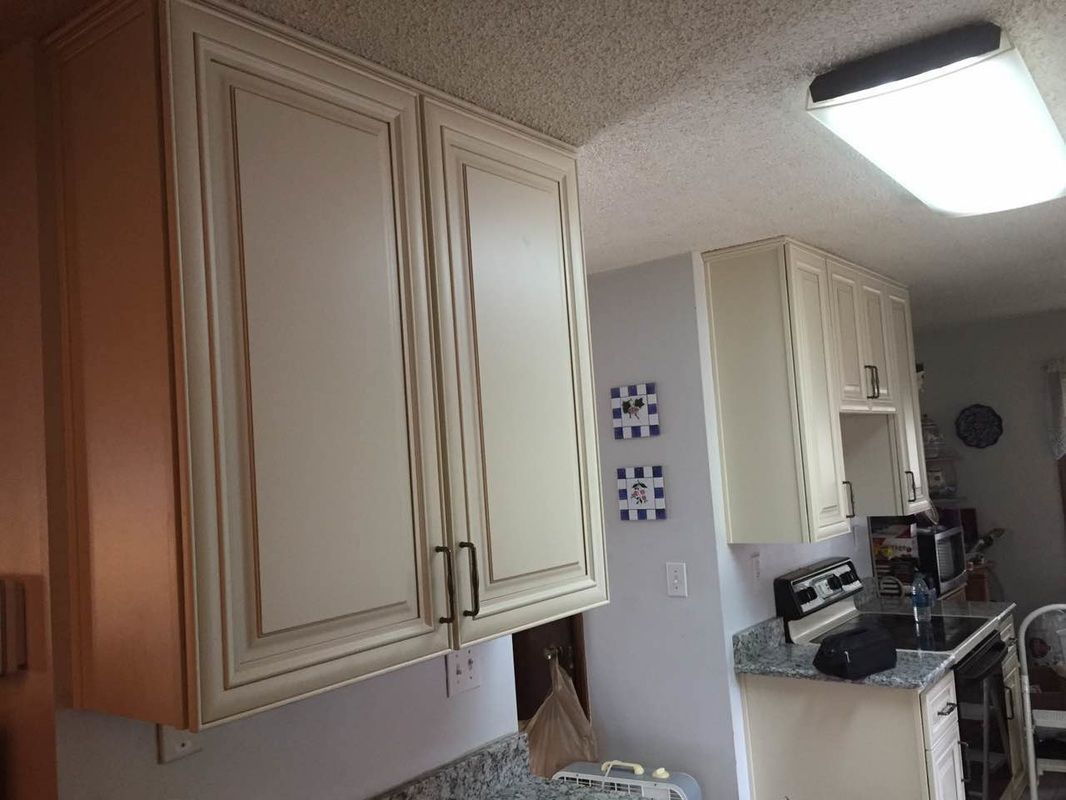 A kitchen with white cabinets and a stove top oven