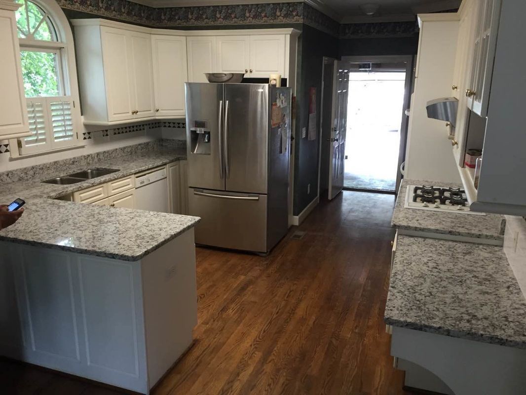 A kitchen with stainless steel appliances and granite counter tops.