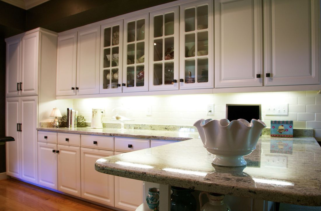 A kitchen with white cabinets and a bowl on the counter.