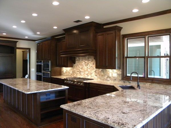 A kitchen with granite counter tops and wooden cabinets