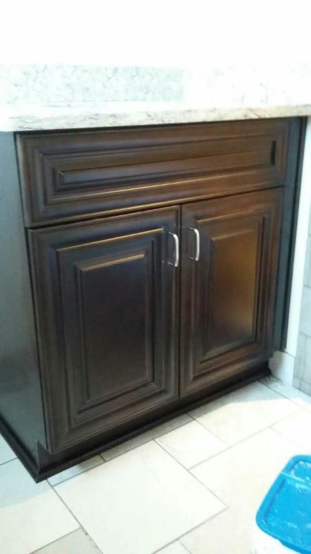 A bathroom vanity with dark wooden cabinets and a white counter top.