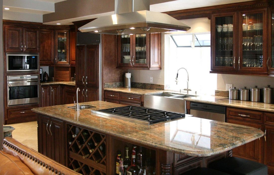 A kitchen with a large island and a stove top oven