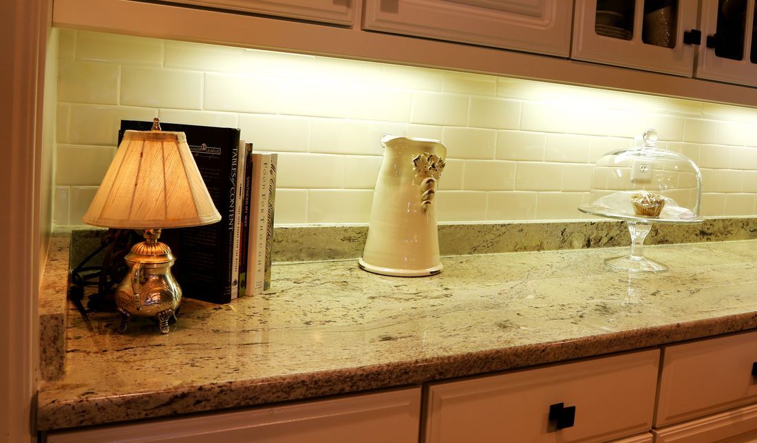 A lamp is sitting on top of a counter in a kitchen.