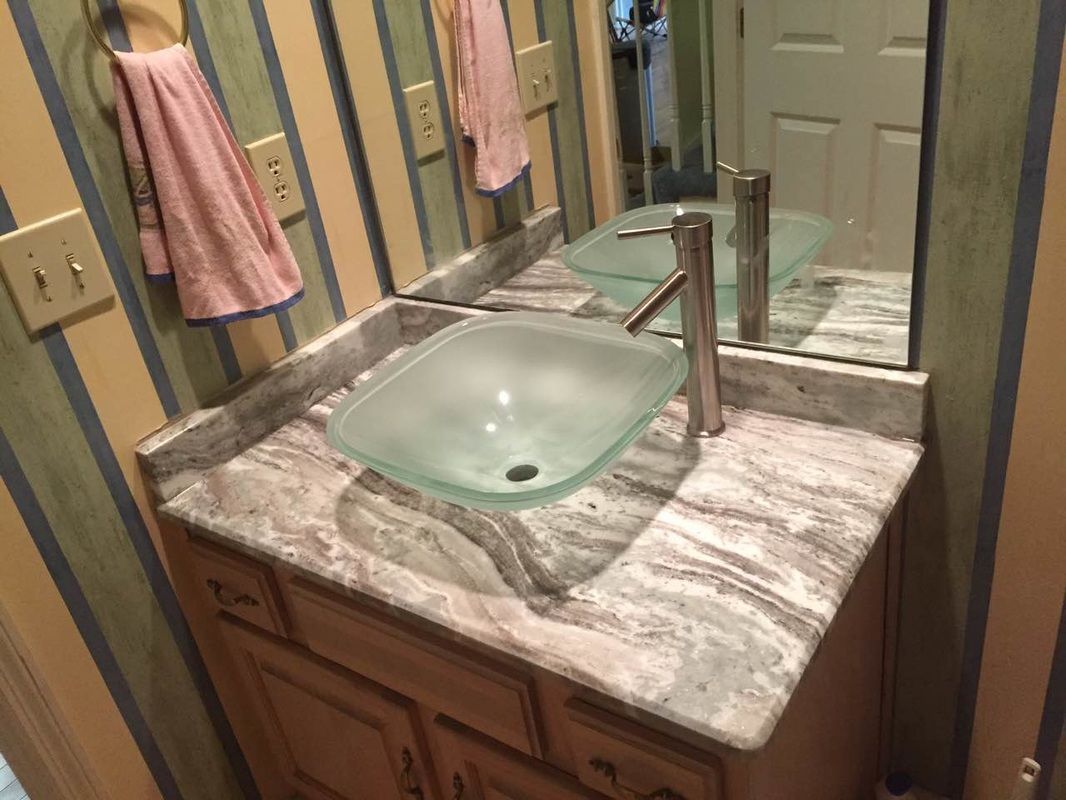 A bathroom sink with a glass bowl and a mirror.