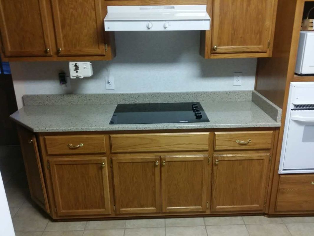 A kitchen with wooden cabinets and a stove top oven