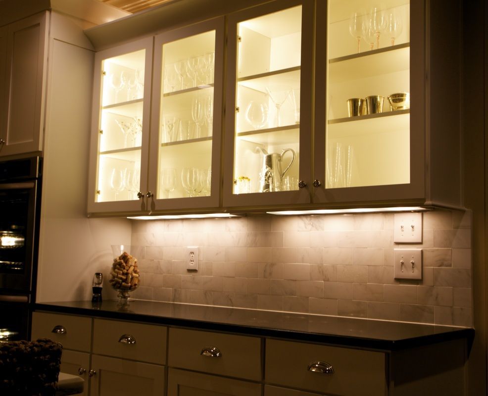 A kitchen with a lot of glass cabinets and drawers