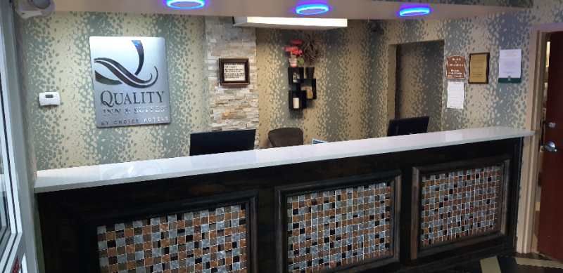 The front desk of a hotel with a sign that says quality