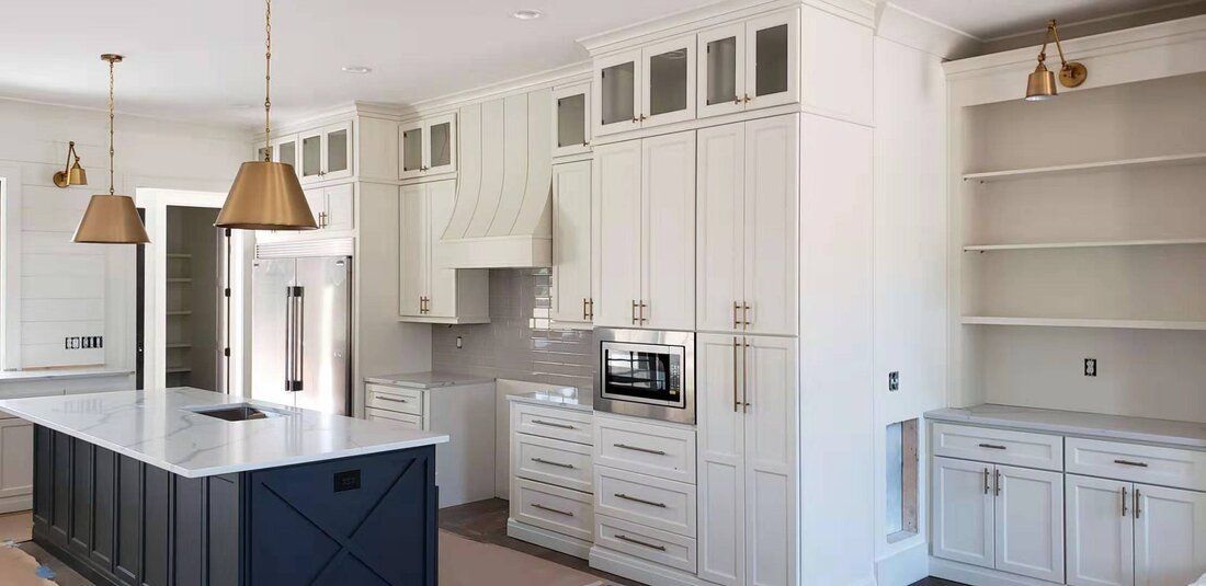 A kitchen with white cabinets and a blue island.
