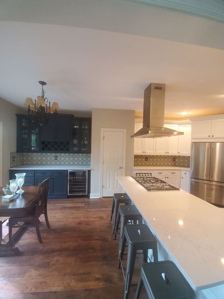 A kitchen with a table and stools and a stove top oven