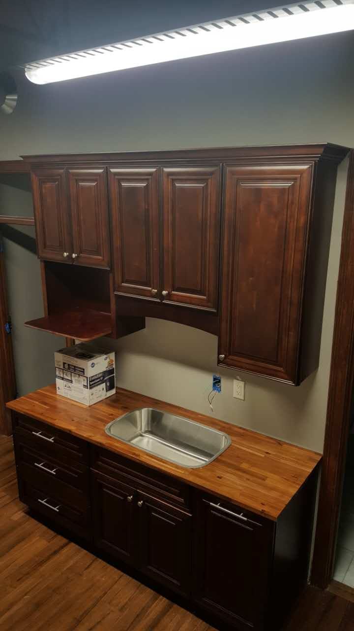 A kitchen with wooden cabinets and a sink.