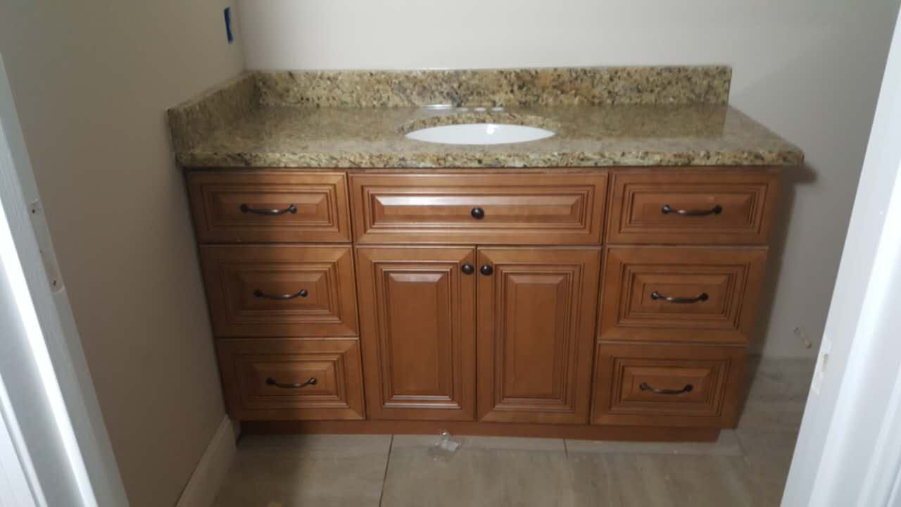A bathroom vanity with wooden cabinets and granite counter tops