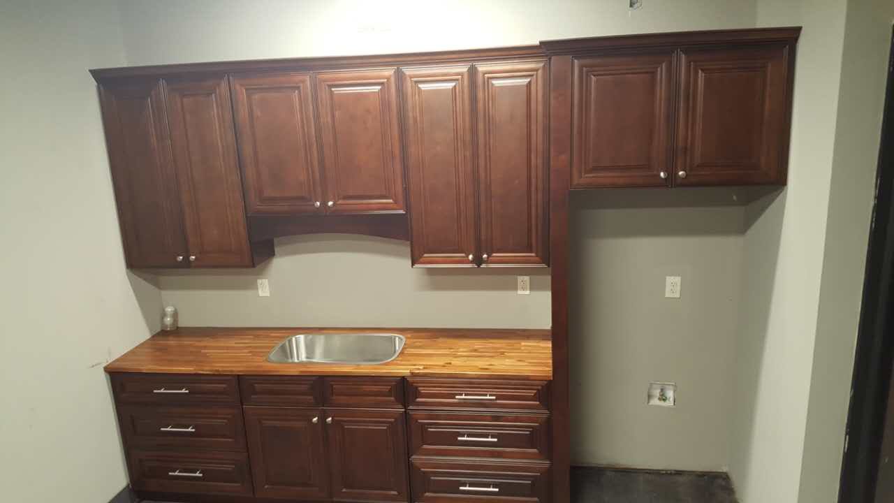 A kitchen with wooden cabinets and a sink.