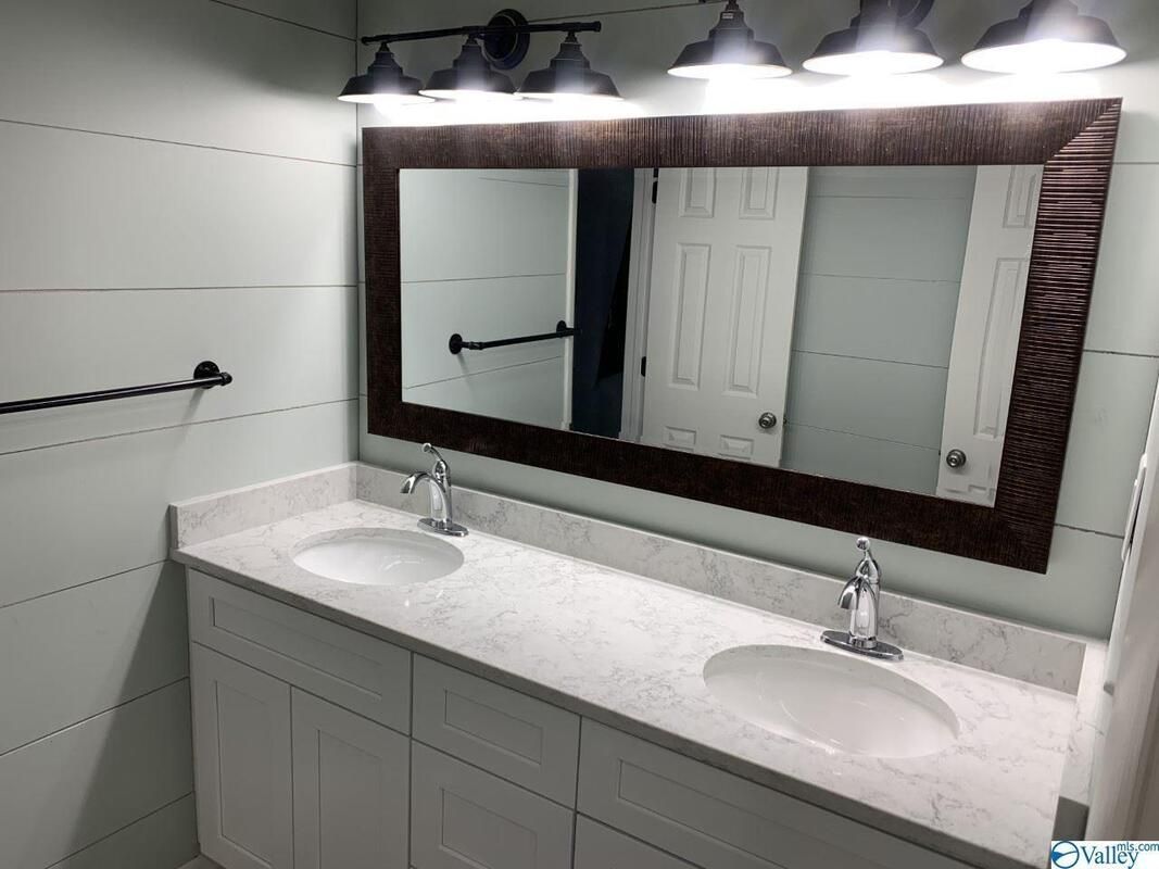 A bathroom with two sinks and a large mirror