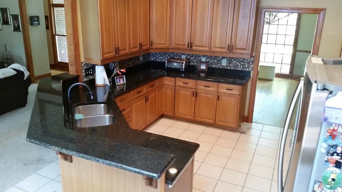 A kitchen with wooden cabinets and black granite counter tops