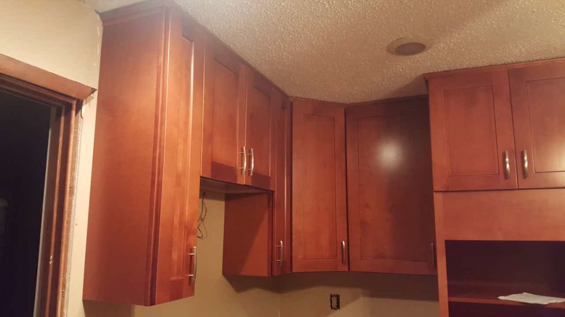 A kitchen with wooden cabinets and a window.
