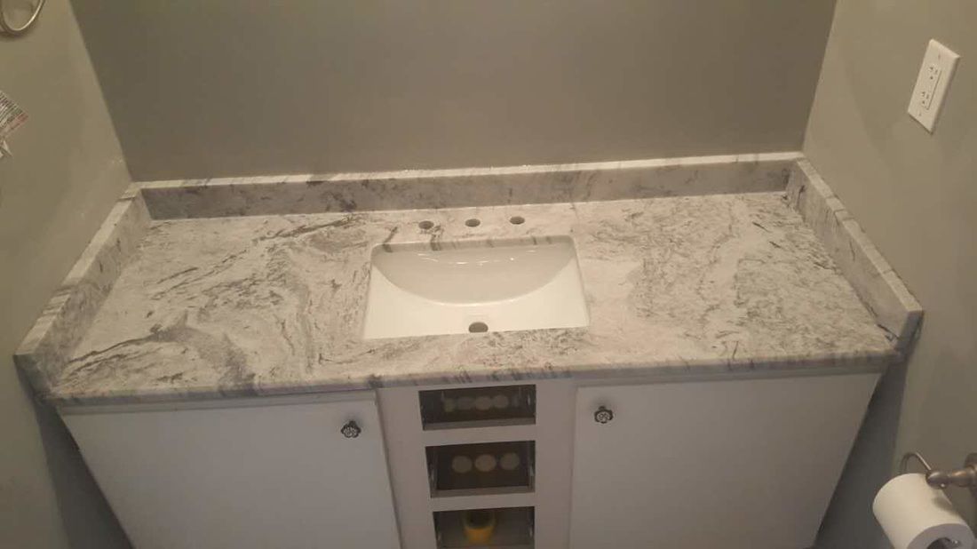 A bathroom vanity with a sink and a toilet paper roll.