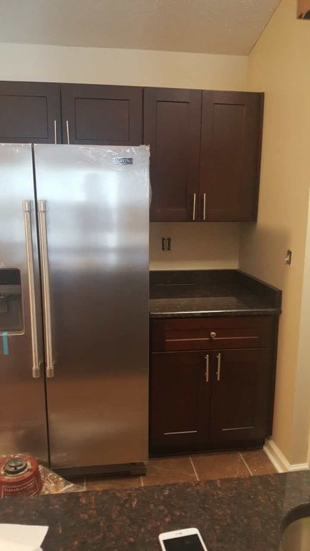 A kitchen with stainless steel appliances and wooden cabinets.