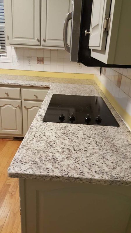 A kitchen with granite counter tops and a stove top oven.