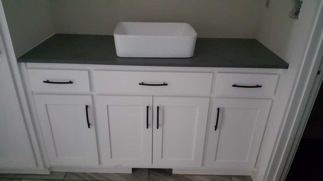 A bathroom vanity with a sink on top of it.